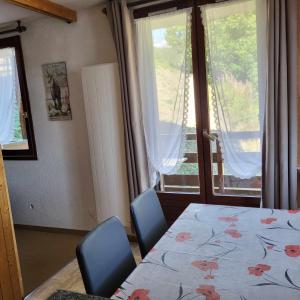 um quarto com uma cama, 2 cadeiras e uma janela em Enjoy em Puy-Saint-Vincent