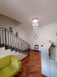 ein Wohnzimmer mit einem gelben Sofa und einer Treppe in der Unterkunft HOTEL POSIDONIA INN SAPRI in Sapri