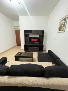 sala de estar con sofá y TV en DEPARTAMENTO 412 en Mendoza