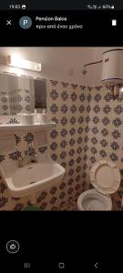 een badkamer met een wastafel en een toilet bij Pension Balos in Koumeika