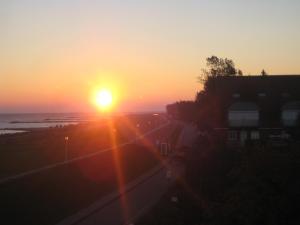 a sunset over the ocean with the sun setting at Ostsee-Ferienwohnung Kalifornien in Kalifornien