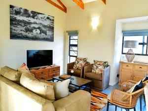 Ndlovu Bushvilla at Elephant Rock Eco Estate في Mica: غرفة معيشة مع أريكة وتلفزيون