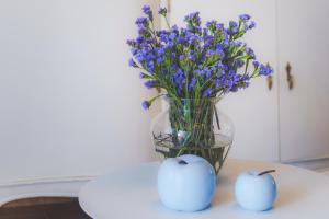 two apples and a vase with purple flowers on a table at Atlantic View La Caleta Adeje in Adeje +16 photos