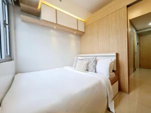Un dormitorio con una gran cama blanca y una ventana en Grass Residences 25th T5, en Manila