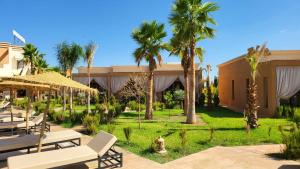 a resort with palm trees and a patio at Hôtel Jardins de lina et lea in Marrakesh