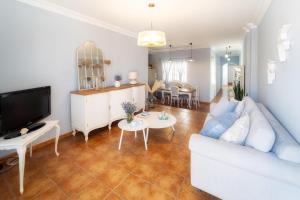 a living room with a white couch and a tv at Atlantic View La Caleta Adeje in Adeje