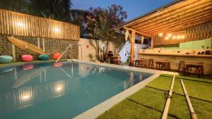 a swimming pool in a backyard with a table and chairs at Puerto Bamboo in Máncora