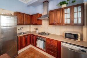 a kitchen with wooden cabinets and a stainless steel refrigerator at Atlantic View La Caleta Adeje in Adeje