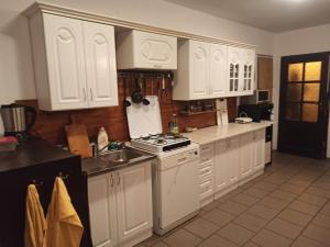 cocina con armarios blancos, fogones y fregadero en Pokoje, kwatery prywatne przy stoku w Zieleńcu en Duszniki Zdrój