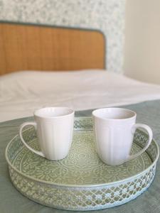 two coffee cups sitting on a tray on a table at La chambre de Madeleine in Commercy