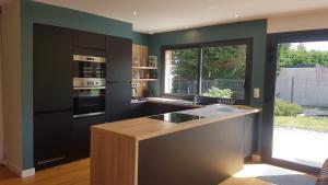a kitchen with black cabinets and a large window at Cozy and welcoming, Pretty quiet holiday home, Crozon peninsula, Camaret-sur-mer in Camaret-sur-Mer