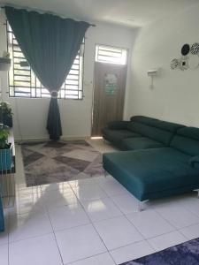 a living room with a green couch and a window at Creatills luxury homestay Kulim & hi-tech in Kulim