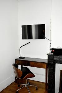 a desk with a chair and a desk with a television at CdH Lantiez in Paris