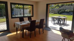 a dining room with tables and chairs and sliding glass doors at Cozy and welcoming, Pretty quiet holiday home, Crozon peninsula, Camaret-sur-mer in Camaret-sur-Mer