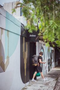 un homme avec un sac à dos marchant dans une rue dans l'établissement Selina San Jose, à San José