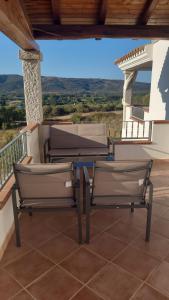 een patio met 2 stoelen en een tafel op een balkon bij SAS DOMOS De BADDE MANNA in Torpè