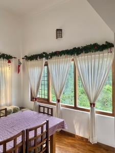 Pristine Hills في Meppādi: غرفة طعام مع طاولة مع أغلفة عيد الميلاد