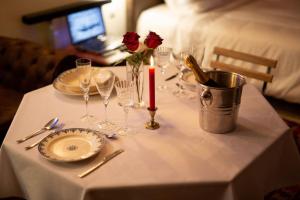 einen Tisch mit Weingläsern, eine Kerze und Rosen in der Unterkunft Bulle Romantique . Jacuzzi . Châteaux de la Loire in Vouvray