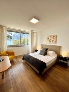 um quarto com uma cama e uma grande janela em Torbole Aparthotel em Nago-Torbole
