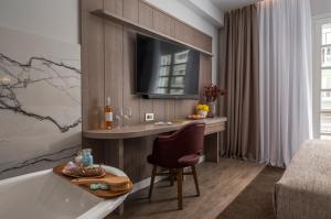 a bathroom with a tub and a table and a chair at No 39 Svolou Suites in Thessaloniki