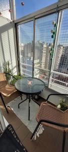 balcón con mesa, sillas y vistas a la ciudad en MIRALEJOS BUENOS AIRES en Buenos Aires