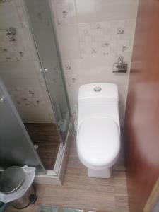 uma casa de banho com um WC branco e um chuveiro em Casa Rionegro em Bogotá