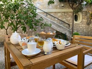 una mesa de madera con comida y bebidas. en Le Jardin D'Elma en Vence