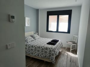 a small bedroom with a bed and a window at Dindurra Gijón Centro-Parking gratuito in Gijón