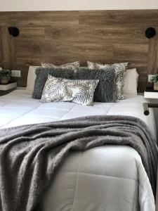 Una gran cama blanca con una manta. en Aromos Lodge- Chacras de Coria- en Luján de Cuyo