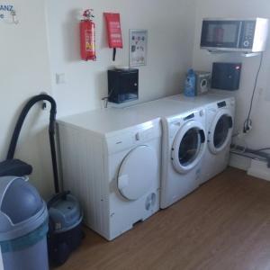 a laundry room with a washing machine and a fire extinguisher at Monteurzimmer in Hamburg West bei Hansezimmer in Hamburg