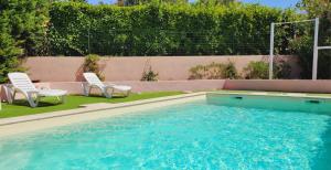 una piscina con 2 sillas de jardín y un par en Appartement, en Montélimar
