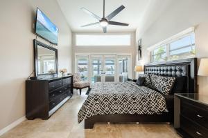 a bedroom with a bed and a dresser and a television at Villa Thunderbird View, Cape Coral in Cape Coral +73 photos