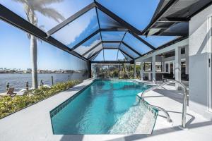 an indoor swimming pool in a house with a glass ceiling at Villa Thunderbird View, Cape Coral in Cape Coral
