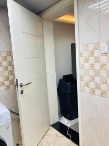 a bathroom with a toilet and a white door at Yoi Pod Hostel - Deira Al Rigga in Dubai