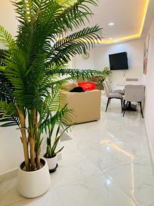 a living room with palm trees and a couch at Yoi Pod Hostel - Deira Al Rigga in Dubai