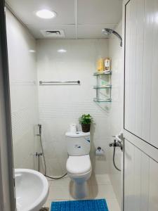 Baño blanco con aseo y lavamanos en Yoi Pod Hostel - Deira Al Rigga en Dubái