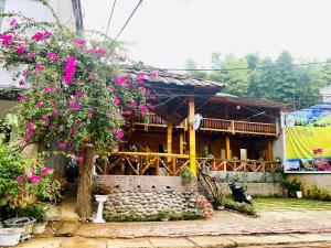 a house with flowers in front of it at Sun Hill's House in Cham Ta Lao
