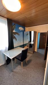 a room with a table and a chair and a window at Bartels Stadt-Hotel in Werl