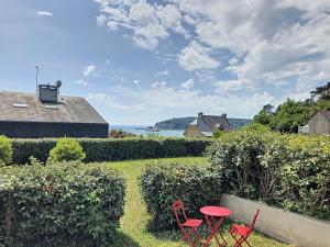 two red chairs and a table in a yard at Appartement Crozon, 3 pièces, 4 personnes - FR-1-370-68 in Crozon