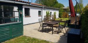 a patio with a table and chairs and a house at Ferienhaus Möwe in Hessenburg