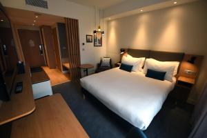 una camera con un grande letto in una camera d'albergo di Holiday Inn Dijon Sud - Longvic, an IHG Hotel a Digione