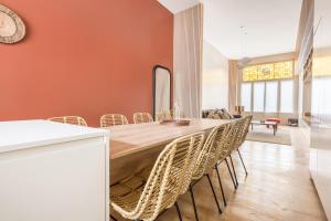 una sala da pranzo con un lungo tavolo in legno e sedie di Luxueux Logement Design 4 ch Climatisé a Lille