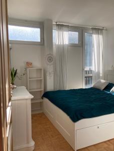 een witte slaapkamer met een bed en een raam bij Via Funghi, po prostu dom in Warschau