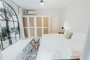 a white bedroom with a bed and a large window at Casa La Sultana: Amazing new house with pool in Valladolid
