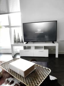 a living room with a flat screen tv on a table at DTLA Luxury Condo with Pool, Gym, Work Pods & Conference Room in Los Angeles