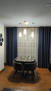 uma mesa no meio de uma sala com cortinas azuis em Wohnung Queens Deluxe em Bogotá
