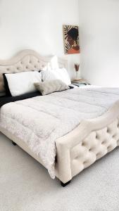 una camera da letto con un grande letto con lenzuola e cuscini bianchi di DTLA Luxury Condo with Pool, Gym, Work Pods & Conference Room a Los Angeles