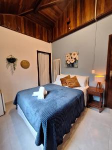 a bedroom with a large bed with a blue blanket at Pousada Schueng in Trindade