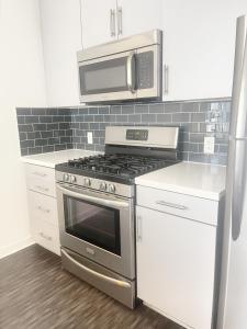 a kitchen with a stove and a microwave at DTLA Luxury Condo with Pool, Gym, Work Pods & Conference Room in Los Angeles