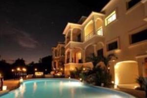 a swimming pool in front of a building at night at Villa Talia, Relax, beach & Nature in Puerto Aventuras